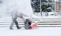 Snow-removal work with a snow blower. Man Removing Snow. heavy precipitation and snow pile Royalty Free Stock Photo