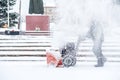 Snow-removal work with a snow blower. Man Removing Snow. heavy precipitation and snow pile Royalty Free Stock Photo