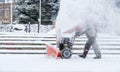 Snow-removal work with a snow blower. Man Removing Snow. heavy precipitation and snow pile Royalty Free Stock Photo