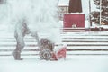 Snow-removal work with a snow blower. Man Removing Snow. heavy precipitation and snow piles. Royalty Free Stock Photo