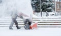 Snow-removal work with a snow blower. Man Removing Snow. heavy precipitation and snow piles. Royalty Free Stock Photo