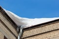 Snow on roof with winter gutter and icicles Royalty Free Stock Photo