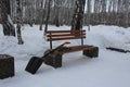 Snow shovel and broom for cleaning on an empty street bench in the Park in winter Royalty Free Stock Photo