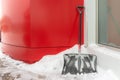 A snow shovel leaning against a building