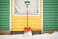 snow shovel leaning against a shed