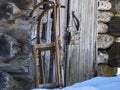 Snow sled outside wooden log cabin hut in winter Royalty Free Stock Photo