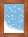 Snow and snowflakes falling through a brown wooden window with blue sky Royalty Free Stock Photo