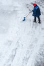 snow storm in the city. Roads and sidewalks covered with snow. Worker shovel clears snow. Bad winter weather. Street cleaning Royalty Free Stock Photo