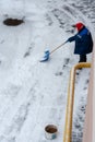 snow storm in the city. Roads and sidewalks covered with snow. Worker shovel clears snow. Bad winter weather. Street cleaning Royalty Free Stock Photo