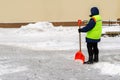 snow storm in the city. Roads and sidewalks covered with snow. Worker shovel clears snow. Bad winter weather. Street cleaning