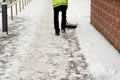 snow storm in the city. Roads and sidewalks covered with snow. Worker shovel clears snow. Bad winter weather. Street cleaning