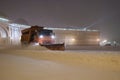 Snow storm in city. Snowplow trucks work at night during winter season blizzards cleaning streets