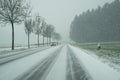 Snow storm on a country road and dangerous road conditions in winter with cars driving Royalty Free Stock Photo