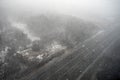 Snow storm in the forest over a road with car. Blizzard in the winter park, top view Royalty Free Stock Photo