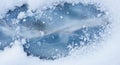 Snow surrounds a patch of ice with visible cracks and a branch tr Royalty Free Stock Photo