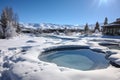 snow swirling around a pool heated naturally by geothermal springs