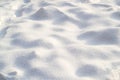 Snow texture on a clear, sunny day. Natural background. Small snow bumps
