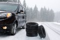 Snow tires near car on road