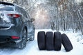 Snow tires near car on road