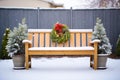snow topped bench with frosted evergreens behind