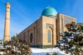 Snow and trees around ornated mosque and minaret of Hazrati Imam complex, religious center of Tashkent