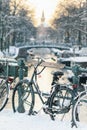 Snow view of a Dutch canal with bicycles in the historic city of Amsterdam Royalty Free Stock Photo