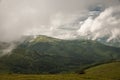 Snow-white clouds floating over the mountains, peaks, which are in contact with the sky. Royalty Free Stock Photo