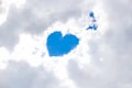 In the snow-white clouds in the gap there is a heart from the blue sky, an angel is nearby. Place for your text. Concept Royalty Free Stock Photo