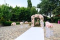 The snow-white path that leads to the altar. Wedding decorations, a wedding arch decorated with peonies, bouquets of