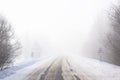 Snow winter landscape. Empty road in fog and Russian slippery road sign Royalty Free Stock Photo