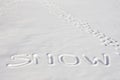SNOW Written In A Snowy Field Beside Footprints Royalty Free Stock Photo