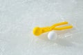 A snowball with a yellow plastic tool for modeling snowballs