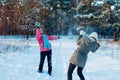 Snowballs playing in winter forest. Family mother and daughter having fun throwing snow outdoors Royalty Free Stock Photo