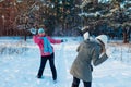 Snowballs playing in winter forest. Family mother and daughter having fun throwing snow outdoors Royalty Free Stock Photo