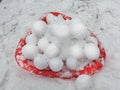 Snowballs on a Sled. Pile of perfect round snowballs on snow outdoors. Background.