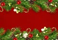 Snowberries with green twigs of Christmas tree, decorations and cones in a festive line arrangements on and red craft paper