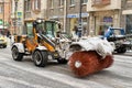 Snowblower with a big brush drives down a city street