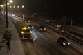 Snowblower and cars on highway in blizzard. Winter in the city. Winter service vehicle at work at night Royalty Free Stock Photo