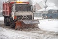 Snowblower cleans the road in the city during a blizzard.