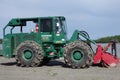 A snowblower parked by a lake in the summertime