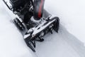 Snowblower at work on a winter day. Removing snow after blizzard snowfall. Clearing the ice. A snow blower is clearing a walkway