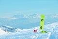 Snowboard equipment laid on the ski slope. Snowy peaks in the background