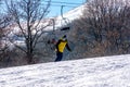 Snowboarder descends a steep slope from a mountain Royalty Free Stock Photo