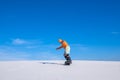 Snowboarder drives off down the sand dune Royalty Free Stock Photo