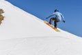 Snowboarder enjoying runs and jumps on spring`s last snow.