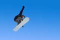 Snowboarder girl does a trick in jumping with a grab against the blue sky. Blue gradient background isolated athlete in Royalty Free Stock Photo