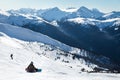 Snowboarder on a hill at the top of Blackcomb, 7th Heaven, with a view looking toward Whistler on a sunny day.