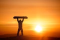 Snowboarder hold snowboard on background of sunset