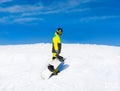 Snowboarder hold snowboard on top of hill