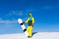 Snowboarder hold snowboard on top of hill